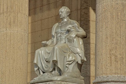 Johann Wolfgang von Goethe sitting on a throne, stone sculpture, monument, ruler, exalted, victor,