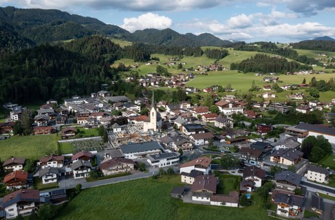 Drone shot, view of the village with parish church, Kössen, Leukental, Tyrol, Austria