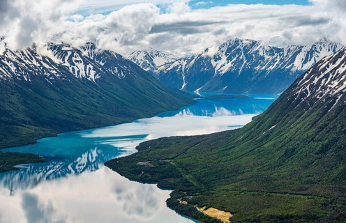 View of snowy mountains in spring and turquoise Kenai Lake with reflection, Slaughter Ridge Trail,