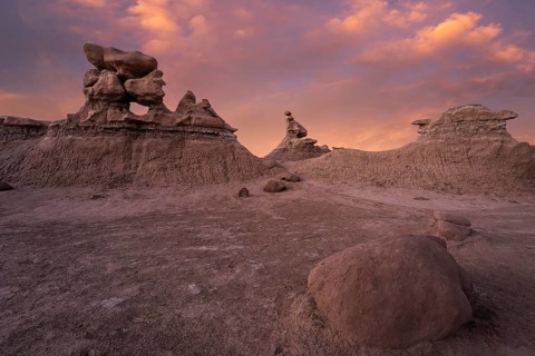 Explore the unique sandstone formations of Goblin Valley State Park, Utah, at sunset. Soft orange