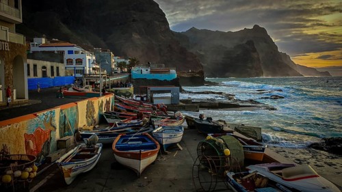 Fishing net and colorful boats on the coast with artistic walls, mural, graffiti and quiet evening