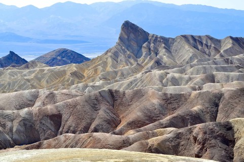 Rugged mountain landscape with distinctive rock formation under blue sky, Zabriskie Point, Death