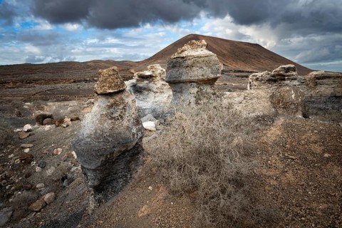 Eroded rock formations, volcanic landscape with dramatic cloudy skies, Ciudad Estratificada or Los