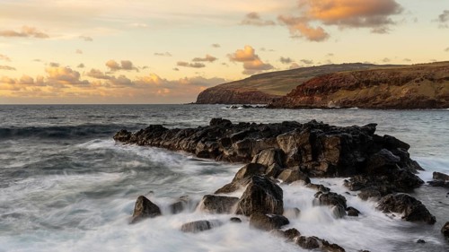 Rocky volcanic coast with surf in evening light, view of the cliffs of the Poike Peninsula, Easter