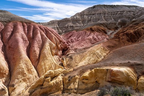 Colored sedimentary rock formations with red, yellow and gray layers, eroded Badlands landscape