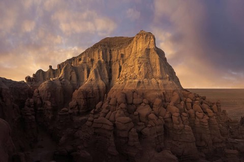 Captivating sandstone formations at Goblin Valley State Park bathed in warm, golden-hour light. The