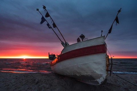 Fishing boat on the beach at sunset. Baltic sea