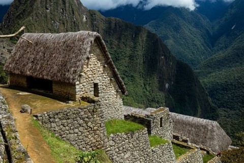 Breathtaking landscape of Machu Picchu in Peru, featuring an ancient Inca hut with a thatched roof