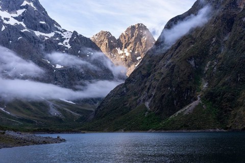 Landscape in New Zealand with mountains and lake. Lake Marian in the evening with clouds coming in.