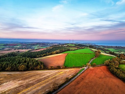 Sunset of Devon Farms and Fields over Berry Pomeroy from a drone, Totnes, England, United Kingdom