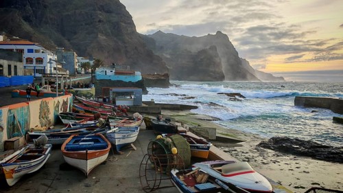 Coast with rows of colorful fishing boats and a dramatic evening sky, Ponta do Sol, Santo Antao,