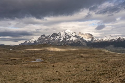 Snow-covered mountain range of the Paine massif with the Torres del Paine granite towers, wide
