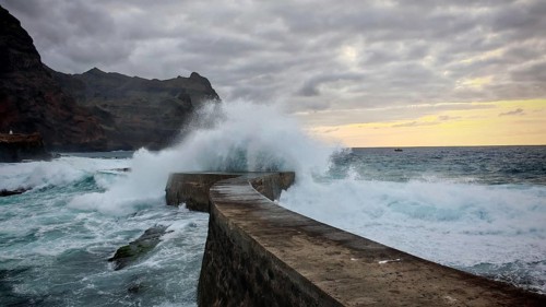 Coastal pier surrounded by gigantic waves and dramatic ocean vibes in the evening light, Ponta do
