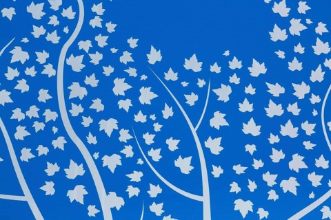 Close-up of white maple leaves in the wind theme motifs on backlit blue tinted plexiglass panel