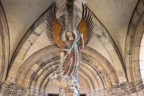 Archangel Michael at the entrance to the portal of the parish church of St. Michael. City view of