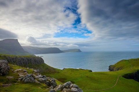 Rocky coastal landscape with cloudy sky and green grass, Waterstein Head, Waterstein, Isle of Skye,