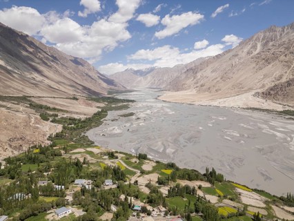 A breathtaking view of Charasa in Nubra Valley, India, showcasing lush green fields, a winding