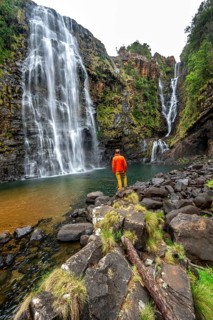 Young man standing in front of a waterfall, Lisbon Falls, long exposure, near Graskop, Mpumalanga,