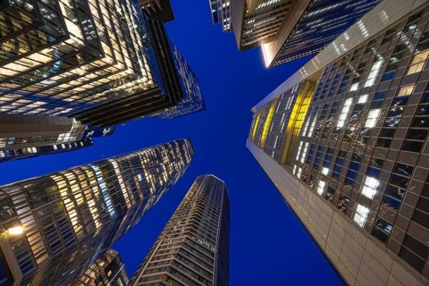 The glowing skyscrapers of Frankfurt's banking skyline rise into the blue evening sky, Frankfurt am