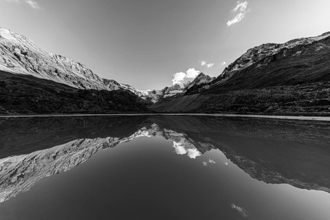 The Moiry glacier and mountain peaks are reflected in Lac de Chateaupre, black and white photo, Val