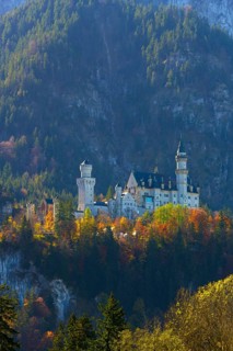 Fairytale castle in autumn, surrounded by colourful trees in an alpine landscape, Neuschwanstein