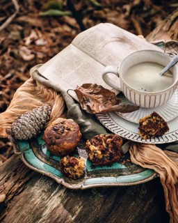A serene autumn setting features pumpkin chocolate chip muffins on a vintage plate, accompanied by