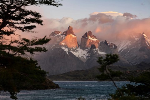 Cuernos del Paine in morning light, granite peaks with clouds and snowfields, Lake Pehoé in the