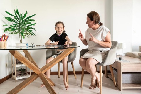 A loving family shares a joyful moment with a mother playing puzzle with disabled girl who has a