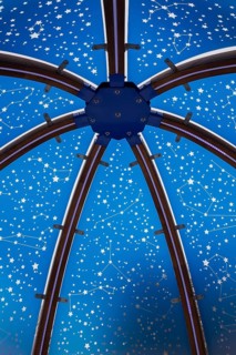 Close-up of backlit blue tinted plexiglass and curved wood panels canopy decorated with white