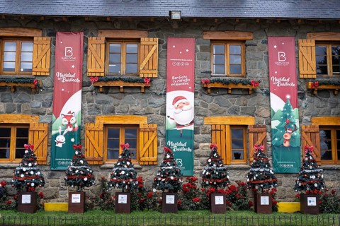 Christmassy decorated stone façade of the Centro Cívico with Navidad en Bariloche banners,