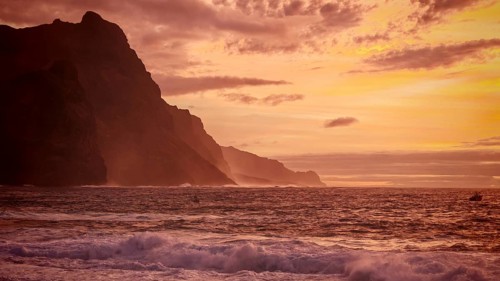 Dramatic silhouette of mountains during an intense sunset in shades of orange, Ponta do Sol, Santo