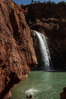 OUZOUD, MOROCCO - OCTOBER 5, 2024: A Moroccan young man jumps from the high rock into the water