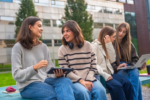 Group of female students collaborating on a project and studying with digital tablet and laptop,