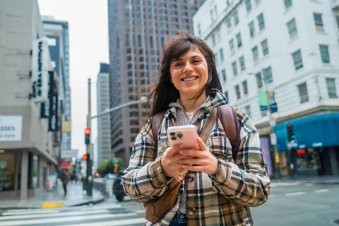 Young woman confidently navigating san francisco's urban environment, smiling while holding a
