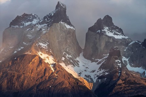 Cuernos del Paine, granite peaks with snow in the morning light, clouds moving around the rock