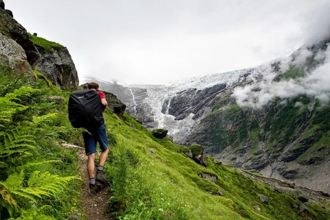 Mountaineers on a hiking trail, cloudy mountain landscape with Grindelwald-Fiescherfirn glacier,