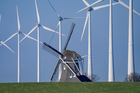 Poldermolen De Goliath windmill stands between the high-tech wind turbines in Eemshaven, historic