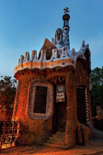 House with tower and souvenir shop at dawn, sign with inscription Park Güell, entrance at sunrise,