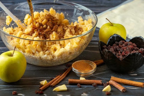Mix apple pieces and ingredients with cinnamon and rum in a bowl for apple strudel