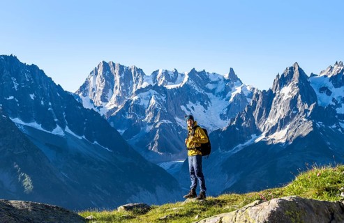 Young man in front of impressive mountain landscape in morning light, picturesque mountain