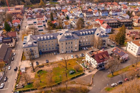 Building complex with adjacent residential buildings and green space, embedded in an urban context,