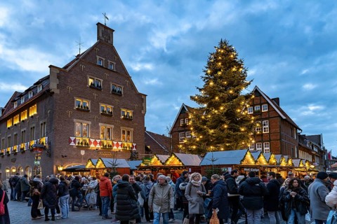 Christmas market or Christmas village at the Kiepenkerl memorial at dusk, Münster, North