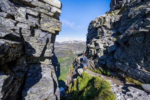 Climbers between rocks, climb to Innerdalstårnet peak, Innerdalen high valley, Trollheimen Mountain