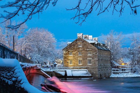 Illuminated Moulin Neuf water flow control dam and walkway over Des Mille-Iles river plus New Mill