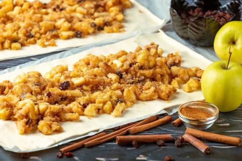Apple and cinnamon filling spread over dough pieces