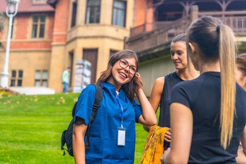 Group of diverse young women enjoying a lively conversation and sharing a joyful moment outdoors on