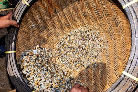 Close-up of basket of rocks and sand held by hands, The sapphire and gemstone mines at Ratnapura in