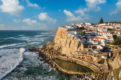 Azenhas do Mar is a picturesque fishing village perched on a cliff by the Atlantic Ocean. Colorful