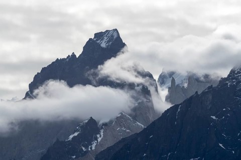 Cloudy rock peaks of Cuernos del Paine, rugged granite towers with remnants of snow, Torres del