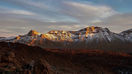 Mirador El Tabonal Negro, mountain landscape at sunset, snow-capped peaks in reddish light, Teide